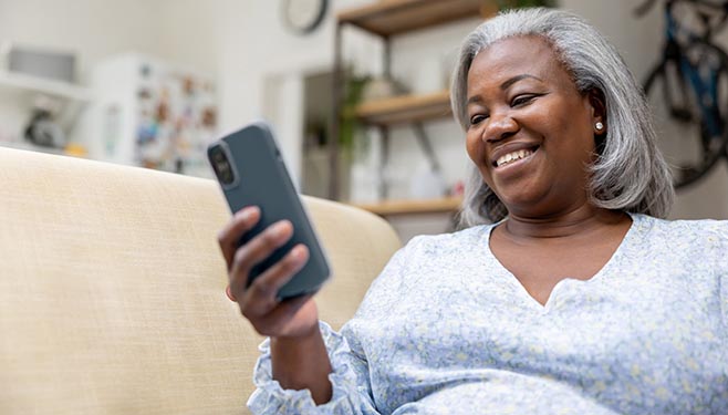 Woman smiling while holding a cellphone