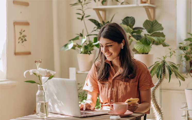 woman on laptop and phone