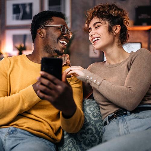 man with mobile phone and woman smiling