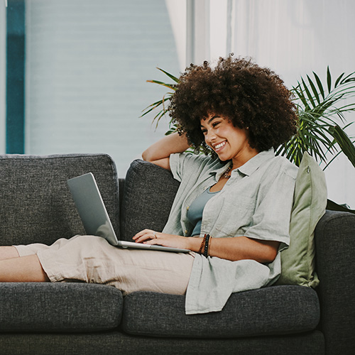 Woman sitting on a couch with a laptop