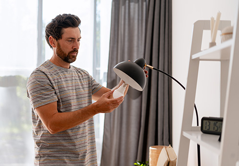 Man putting lightbulb in a lamp