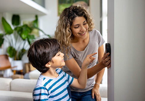 Woman and boy adjusting thermostat