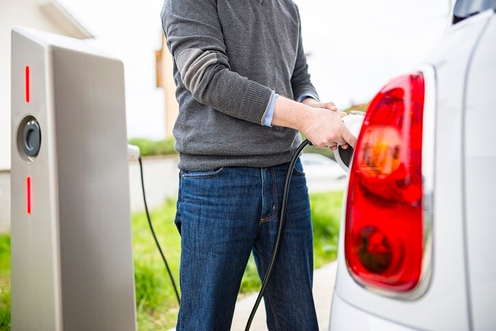 Man charging electric vehicle