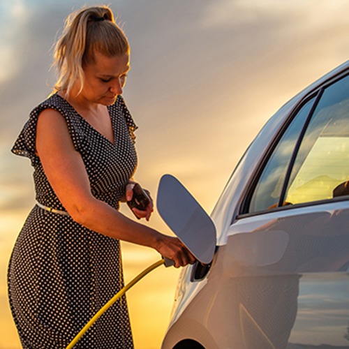 Woman charging electric vehicle