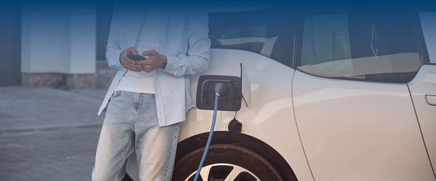 man charging electric vehicle