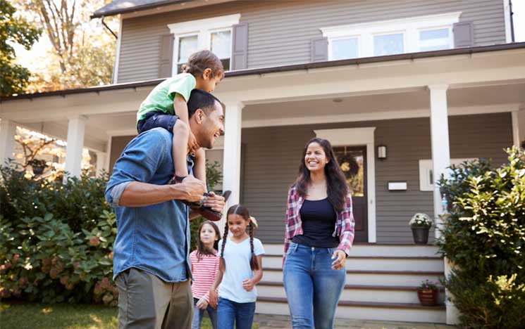 happy family in front of their home